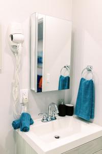 a bathroom with a sink with a mirror and blue towels at Casa Cordova Apartments By Lowkl in Fort Lauderdale +87 photos