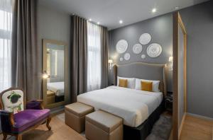 プラハにある987 デザイン プラハ ホテルのベッドルーム(大型ベッド1台、紫色の椅子付)