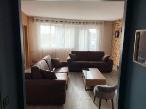 a living room with two couches and a coffee table at Au cœur de Lisieux 83 m2 et vue sur la Basilique in Lisieux