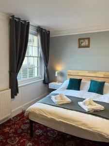 a bedroom with a bed with two towels on it at Castle Inn in Hythe