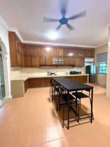 a kitchen with a table and a ceiling fan at Villa Ruby - with private swimming pool in Kota Bharu