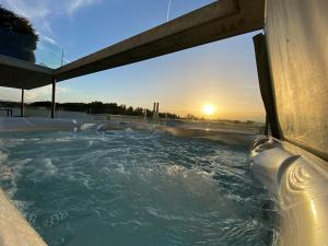 un jacuzzi con la puesta de sol en el fondo en Luxusloft mit warmem Outdoor Whirlpool 