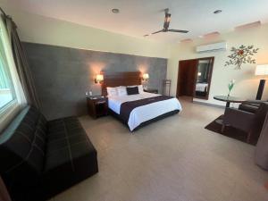 a hotel room with a bed and a couch at Hotel Ecce Inn & Spa in Silao