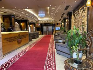 a lobby with a red carpet in a hotel at فندق بردى in Qaryat al Bulush