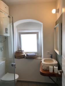 ein Badezimmer mit Fenster, Waschbecken und Toilette in der Unterkunft Casa del Olivo by Casitasconencantoes in Medina-Sidonia