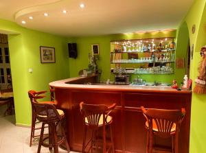 bar w restauracji z zielonymi ścianami i stołkami w obiekcie Party Villa Holiday Rent Balatonfoldvar w Balatonföldvárze