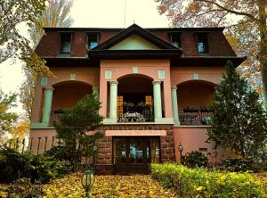 una casa rosa con balcón en la parte superior en Party Villa Holiday Rent Balatonfoldvar, en Balatonföldvár
