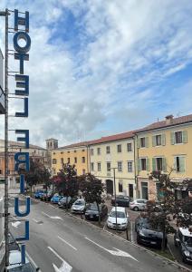 una calle de la ciudad con coches aparcados en un estacionamiento en Hotel Friuli en Cervignano del Friuli