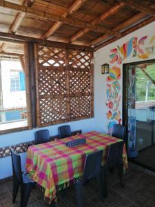 ein Esszimmer mit einem Tisch, Stühlen und einem Fenster in der Unterkunft Casa Italia Guest House in Taganga