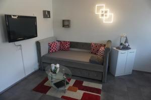 a living room with a couch and a flat screen tv at Sweet Dreams Wellness Appartement in Seefeld in Tirol