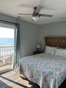 a bedroom with a bed and a view of the ocean at Coastal Memories in North Topsail Beach