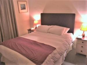 a bedroom with a large bed with two night stands at Bar Hill Lodge in Gatehouse of Fleet