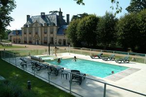 a pool in front of a house with people in it at Logis La Marjolaine in Moulay