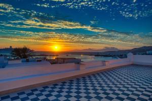 a sunset over a swimming pool with a checkered floor at Josephine Mykonos Town Villa - 1882 in Mýkonos City