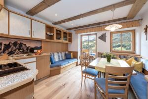 uma cozinha e sala de jantar com mesa e cadeiras em Bergblick App Lärche em Funes