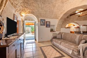 a living room with a couch and a tv at Trulli da Tommaso - Martina Franca in Martina Franca