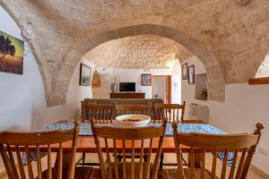 a kitchen and dining room with a table and chairs at Trulli da Tommaso - Martina Franca in Martina Franca