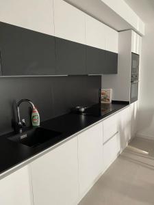 a kitchen with white cabinets and a black counter top at Kobé Place in Barcelona
