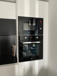 a black oven in a kitchen with white cabinets at Kobé Place in Barcelona