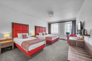 um quarto de hotel com duas camas e uma televisão em Nelly Kellys em Trutnov