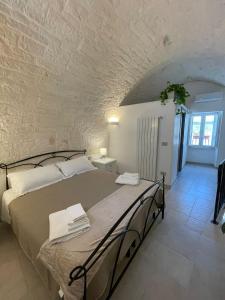 um quarto com uma cama grande numa parede de pedra em Dimora San Nicola em Locorotondo
