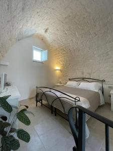 una camera con letto e muro di mattoni di Dimora San Nicola a Locorotondo
