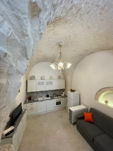 uma cozinha e sala de estar com uma parede de pedra em Dimora San Nicola em Locorotondo