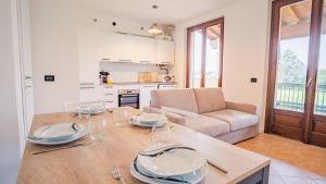 cocina y sala de estar con mesa y sofá en The House in the Vineyard - Italian Homing, en Manerba del Garda