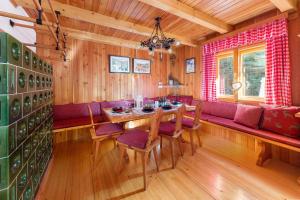 ein Esszimmer mit einem Tisch und einem roten Sofa in der Unterkunft Chalet Trzinka - Triglav National Park in Goreljek