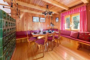 a dining room with a table and a red couch at Chalet Trzinka - Triglav National Park in Goreljek