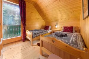 - une chambre avec 2 lits dans une cabane en bois dans l'établissement Chalet Trzinka - Triglav National Park, à Goreljek