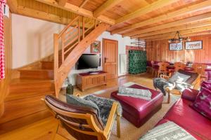 a living room with a couch and a tv at Chalet Trzinka - Triglav National Park in Goreljek