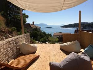 a wooden deck with benches and a view of the water at Eco Sunshine Apartments Lumbarda in Lumbarda