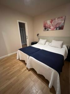a bedroom with a large bed with a blue blanket at Apartamento Sebreñu 1 in Ribadesella