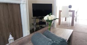 a living room with a vase of flowers on a table at Home from Home near LFC, EFC & train station in Liverpool