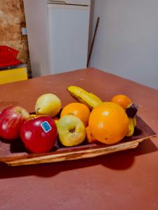 a pile of fruit on a wooden plate on a table at Encuentro de Almas (Soulmate Encounter) in Tinogasta