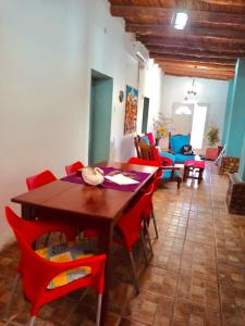 a dining room with a wooden table and red chairs at Encuentro de Almas (Soulmate Encounter) in Tinogasta