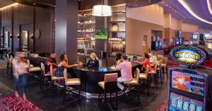 a group of people sitting at a bar in a casino at Southland Casino Hotel in West Memphis
