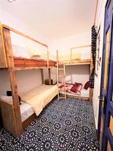 エッサウィラにあるberber hostelの青いフロアのドミトリールームの二段ベッド2台