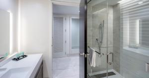 a bathroom with a shower and a glass door at Southland Casino Hotel in West Memphis