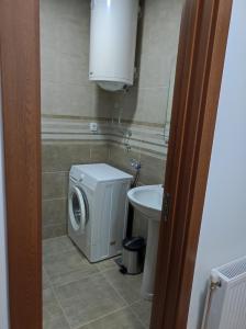 een badkamer met een wasmachine en een wastafel bij SP Apartmani FREE PARKING in Vranje