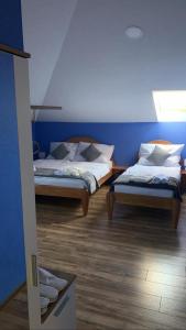 Habitación con 2 camas, paredes azules y suelo de madera. en Mirocki-Raj, en Miroč