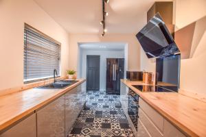 eine Küche mit einer Spüle und einer Arbeitsplatte in der Unterkunft Modernistic 4-bedroom home close to City Centre in Cardiff