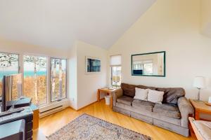 a living room with a couch and some windows at Hawks Nest 58 in Glen Arbor