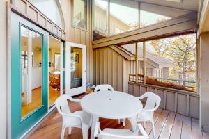 a dining room with a white table and chairs at Hawks Nest 58 in Glen Arbor