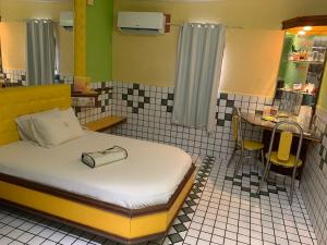 ein kleines Schlafzimmer mit einem Bett und einem Tisch sowie eine Küche in der Unterkunft Motel Estoril (Adult Only) in Recife