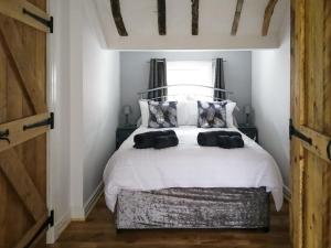 a bedroom with a bed with white sheets and a window at Chase Heys Cottage in Crossens
