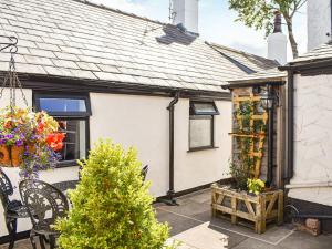 una pequeña casa blanca con un jardín delante de ella en Chase Heys Cottage, en Crossens