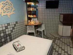 um quarto com uma cama e uma mesa e uma pequena mesa com cadeiras em Motel Estoril (Adult Only) no Recife