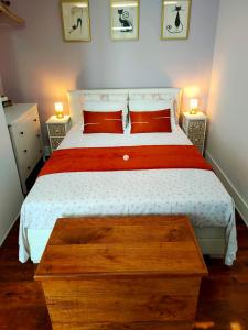 Schlafzimmer mit einem Bett mit einer roten und weißen Bettdecke in der Unterkunft Casa Shardana Lisbon in Lissabon